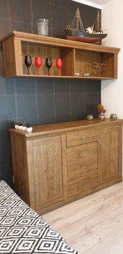 a wooden dresser in a bedroom with red candles on it at Nad Wełną Check-in 24H in Oborniki