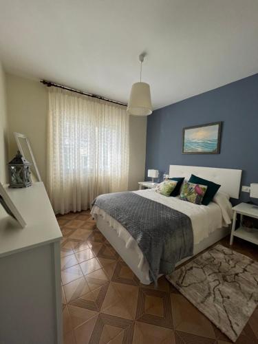 um quarto com uma cama e uma parede azul em Fogar de Aurora em Portomarín
