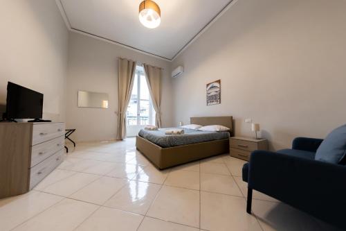 una camera con letto, TV e divano di A Casa di Titto guest house a Napoli