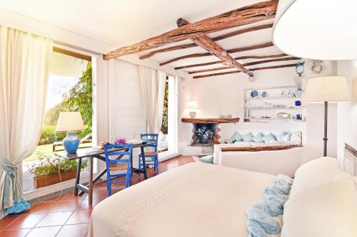 a bedroom with a bed and a table and chairs at Karamare in Stintino