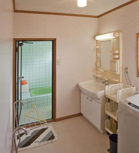 a bathroom with a tub and a sink and a shower at Dormitory Sandanya Guesthouse in Shirahama