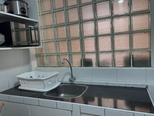 um balcão de cozinha com um lavatório e uma janela em Pershing, depa bonito, 3camas wifi/cable em Lima