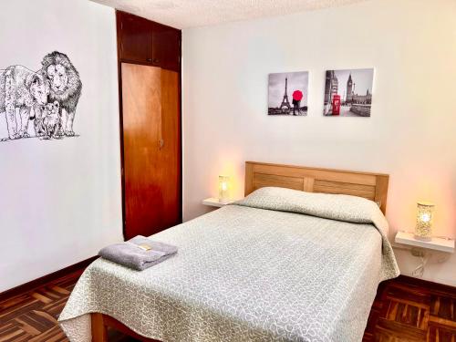1 dormitorio con 1 cama y 2 cuadros en la pared en Pershing, depa bonito, 3camas wifi/cable, en Lima