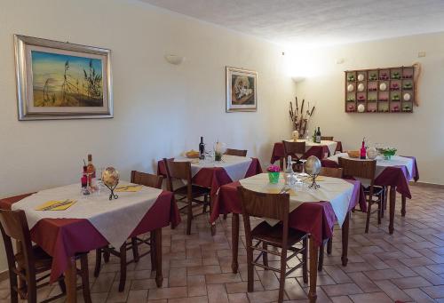 uma sala de jantar com mesas com toalhas de mesa roxas e brancas em B&B Corte degli Struzzi em Pescia Romana