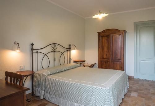 a bedroom with a bed and a wooden cabinet at B&B Corte degli Struzzi in Pescia Romana