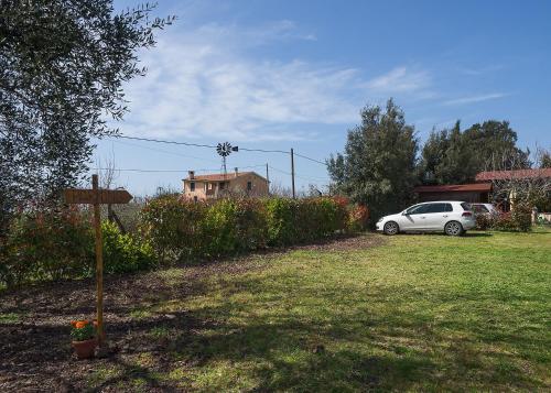a white car parked in a yard next to a house at B&B Corte degli Struzzi in Pescia Romana
