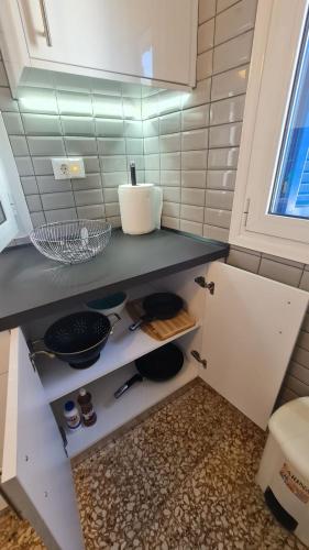 una cocina con encimera con bol y sartenes en Blue and White, en Kremasti