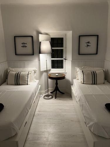 a bedroom with two beds and a table with a lamp at Charming, chic, secluded villa within walking distance from Lorgues in Lorgues