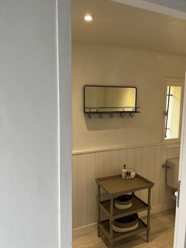 a bathroom with a table and a mirror on the wall at Charming, chic, secluded villa within walking distance from Lorgues in Lorgues