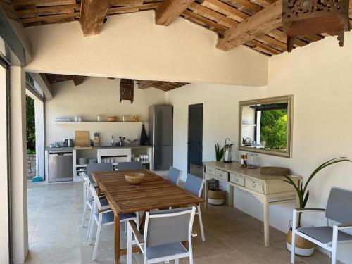a kitchen and dining room with a wooden table and chairs at Charming, chic, secluded villa within walking distance from Lorgues in Lorgues