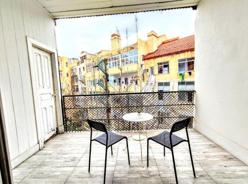 patio ze stołem i krzesłami na balkonie w obiekcie Fernando Pessoa Lisbon Rooms w Lizbonie