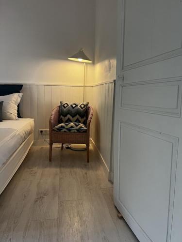a bedroom with a bed and a chair in a room at Charming, chic, secluded villa within walking distance from Lorgues in Lorgues