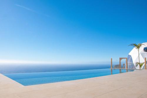 a swimming pool with a view of the ocean at Vi Naturae Glamping in Fajã da Ovelha