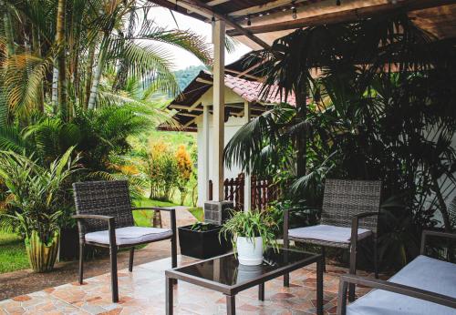 een patio met 2 stoelen en een tafel met planten bij Albergue Turístico Gstir in Pozuzo