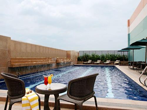 a pool with chairs and tables in it at Eastwood Richmonde Hotel - Multiple-Use Hotel and Staycation Approved in Manila