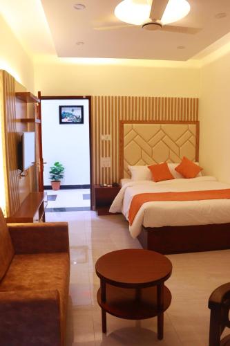Habitación de hotel con cama y sofá en Grand Castle Hotel & Resturant en Comilla