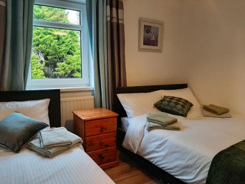 a bedroom with two beds and a window at The Swansea View in Skewen