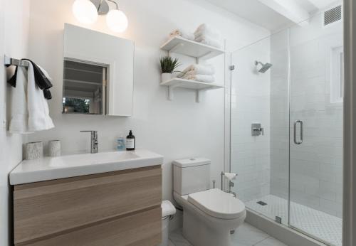a bathroom with a sink and a toilet and a shower at Palm Cottage in Montecito