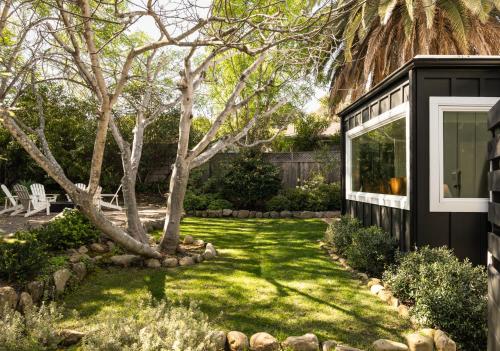 a house with a green yard with a tree at Palm Cottage in Montecito