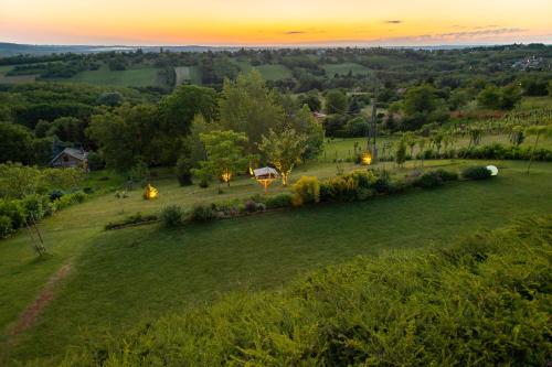 an aerial view of a field with a sunset in the background at AISLAMIENTO, Luxus faház in Zalaegerszeg