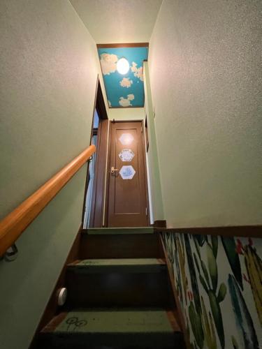 a stairway with a brown door with a ceiling at 舟荘 in Osaka