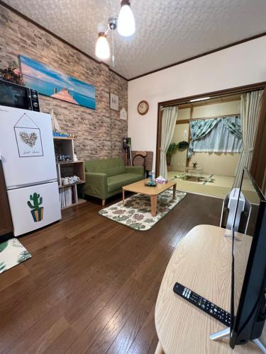 a living room with a green couch and a brick wall at 舟荘 in Osaka