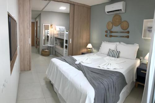 a bedroom with a large white bed in a room at Flat aconchegante no Eco Resort Praia dos Carneiros - Cama Queen in Praia dos Carneiros