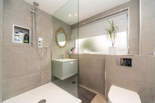a bathroom with a shower and a toilet and a sink at 11 Boutique studio apartment perfect for peaceful getaway, secluded garden, quiet location in High Wycombe