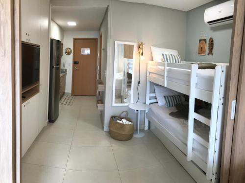 um quarto com 2 beliches e uma televisão em Flat aconchegante no Eco Resort Praia dos Carneiros - Cama Queen em Tamandaré