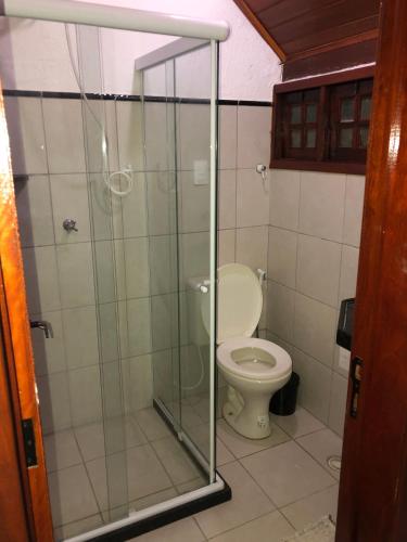 a bathroom with a toilet and a glass shower at Lindo chalé em Gravatá - Condomínio Mont Blanc V in Gravatá