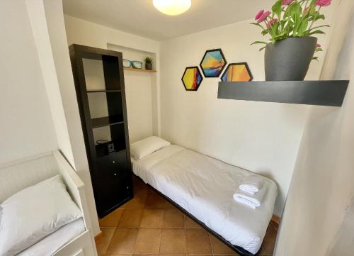 a small room with a bed and a plant on the wall at ETERNA Trastevere Apartment in Rome