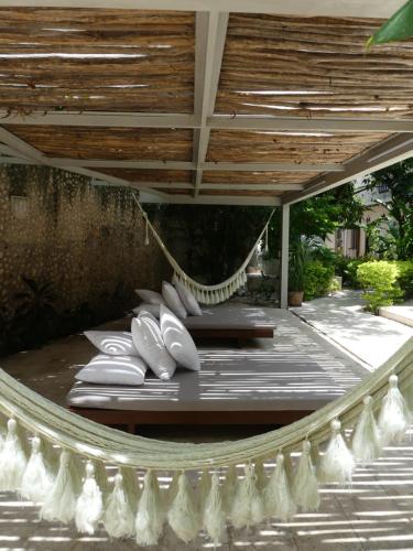 a porch with chairs and a hammock on a patio at Casa Valladolid Boutique Hotel in Valladolid
