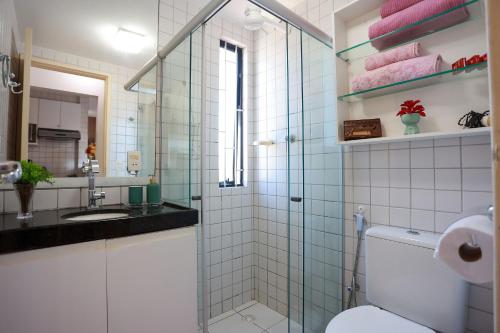 a bathroom with a toilet and a glass shower at Turismo Home Office c/ar a 450m da Praia Ponta Verde in Maceió