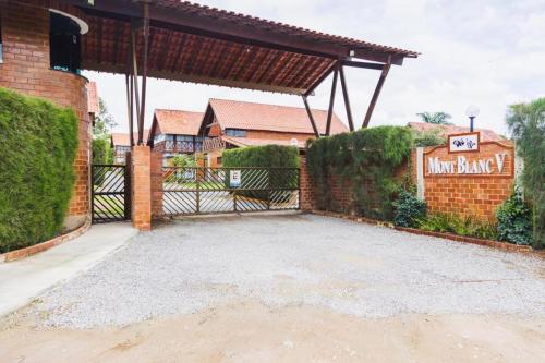 a driveway with a gate in front of a house at Lindo chalé em Gravatá - Condomínio Mont Blanc V in Gravatá