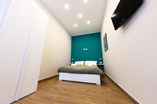 um quarto com uma cama e uma parede em tons de verde em A CASA DI PUPA GUEST HOUSE em Nápoles