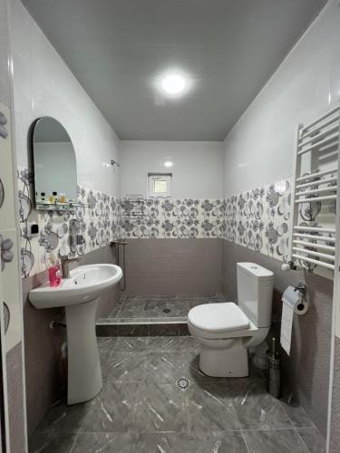 a bathroom with a white toilet and a sink at Orenda in Tʼelavi