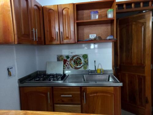 a kitchen with a sink and a stove at Apartamentos con estacionamiento cerca al parque in Támesis