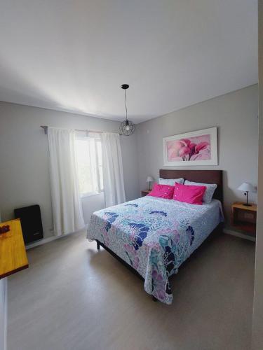 a bedroom with a bed with pink pillows at Alquiler departamento San Lorenzo in Tandil