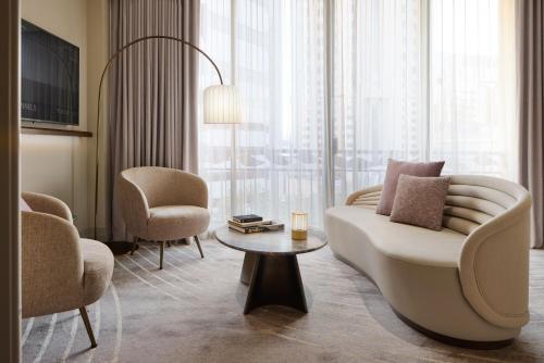 a living room with a couch and chairs and a table at The Playford Adelaide - MGallery in Adelaide