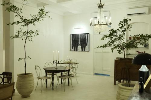 a dining room with a table and chairs and a chandelier at Maison Victoire, boutique hôtel - Pointe-à-Pitre in Pointe-à-Pitre