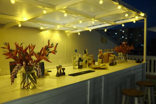 a bar with a vase of flowers and lights at Maison Victoire, boutique hôtel - Pointe-à-Pitre in Pointe-à-Pitre