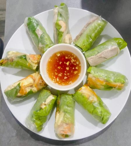 a plate of food with a bowl of dipping sauce at LAM BUNGALOW Resort & Spa in Phu Quoc