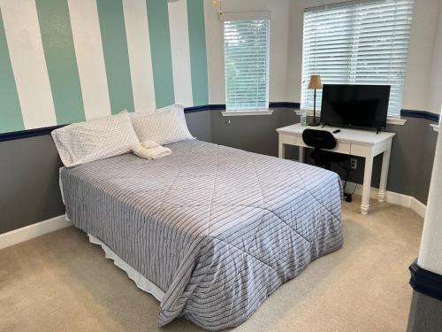 a bedroom with a bed and a desk and a computer at Serenity in Fresno