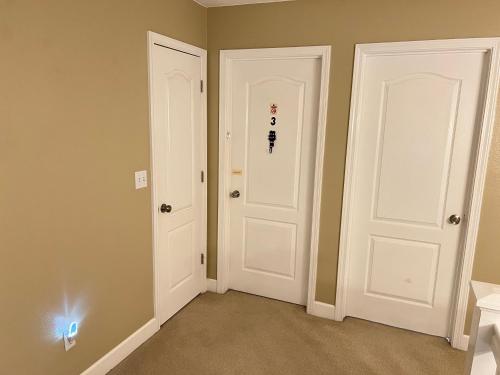 two white doors in a room withaki colored walls at Serenity in Fresno