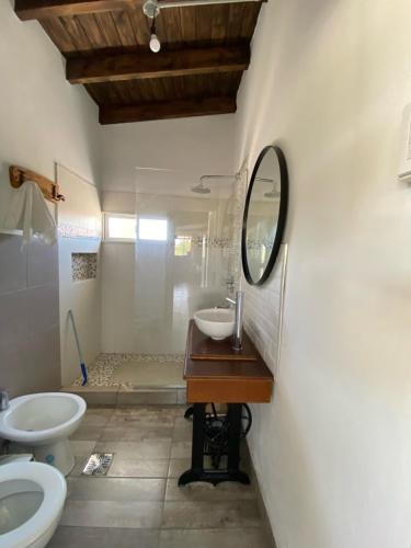 baño con lavabo y espejo en la pared en El rincón del nene en Albardón