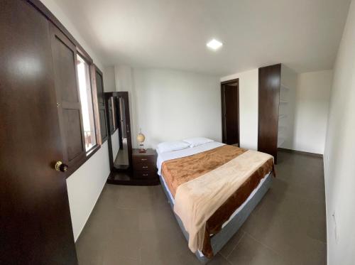 Villa Anny في Quebradagrande: غرفه فندقيه بسرير ونافذه