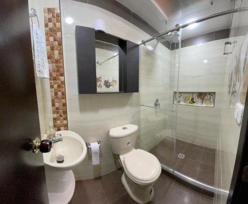 a bathroom with a toilet and a shower and a sink at Villa Anny in Quebradagrande