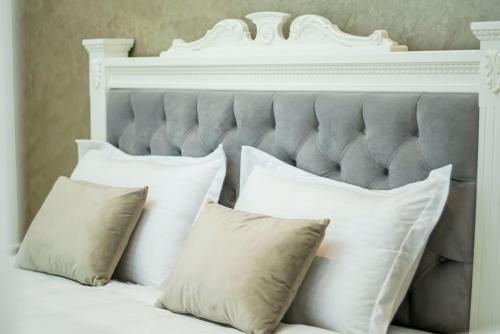 1 cama con almohadas blancas y cabecero blanco en Vila Perla Gjiri Lalzit , Perla Resort, en Durrës