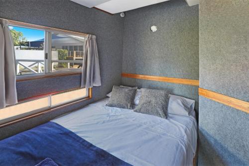 um quarto com uma cama grande e uma janela em Caloundra Houseboats em Pelican Waters