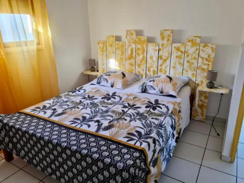 a bedroom with a bed with a blue and white comforter at Domaine de Portland in Le Moule
